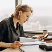 A woman sitting at her desk looking at papers.